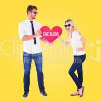Composite image of cool young couple holding red heart