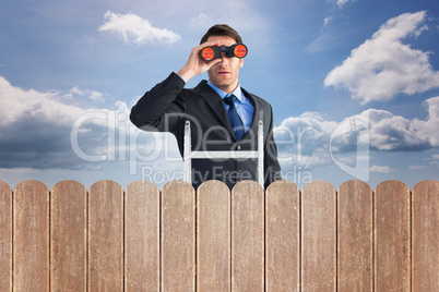 Composite image of businessman looking on a ladder