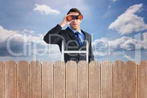 Composite image of businessman looking on a ladder