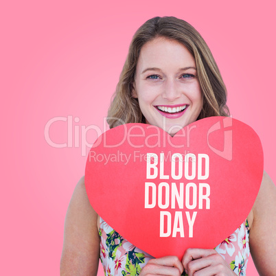 Composite image of woman holding heart card