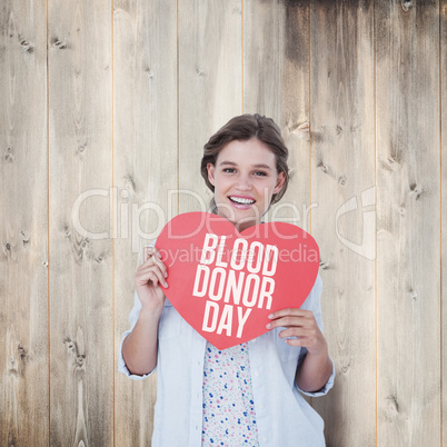 Composite image of woman holding heart card