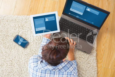 Composite image of brunette woman using her tablet and notebook