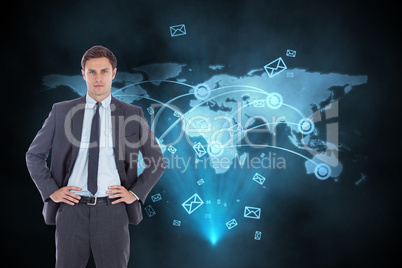 Composite image of serious businessman with hands on hips