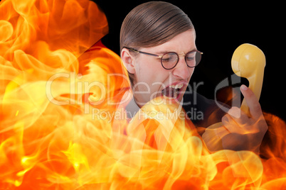 Composite image of geeky businessman shouting at retro phone