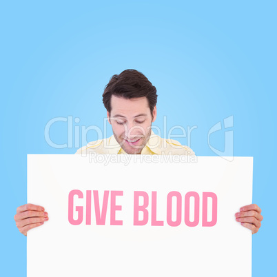 Composite image of attractive man smiling and holding poster