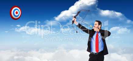 Composite image of focused businessman shooting a bow and arrow