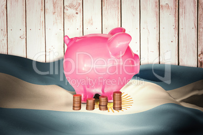 Composite image of coins and piggy bank