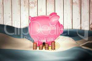 Composite image of coins and piggy bank