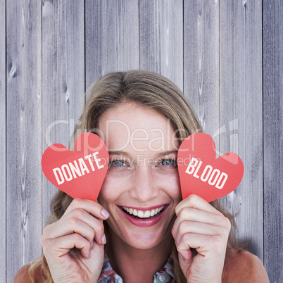 Composite image of woman holding heart cards