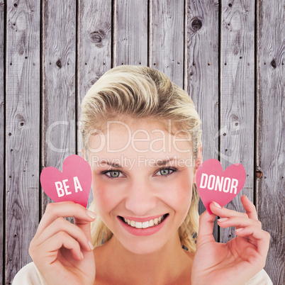 Composite image of attractive young blonde holding little hearts