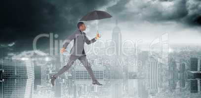 Composite image of businessman walking and holding umbrella