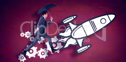 Composite image of businessman jumping holding an umbrella