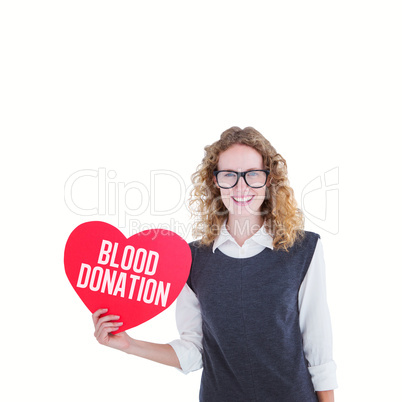 Composite image of geeky hipster holding heart card