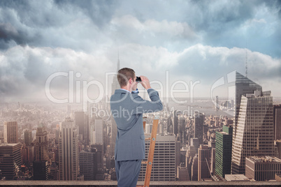 Composite image of businessman looking on a ladder