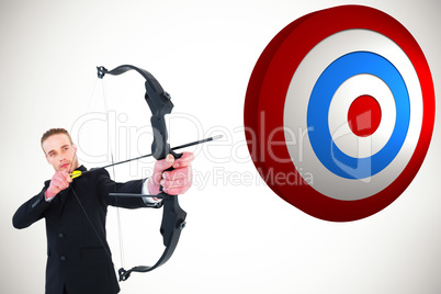 Composite image of concentrated businessman shooting a bow and a