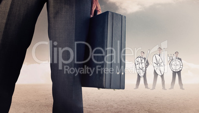 Composite image of businessman holding briefcase