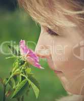 child smelling blossom