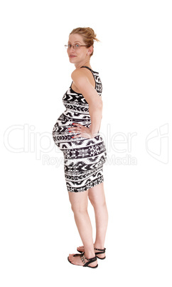 Pregnant woman standing in profile.
