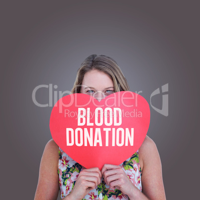 Composite image of woman holding heart card