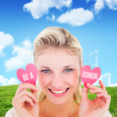 Composite image of attractive young blonde holding little hearts