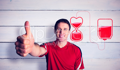 Composite image of football fan in red showing thumbs up