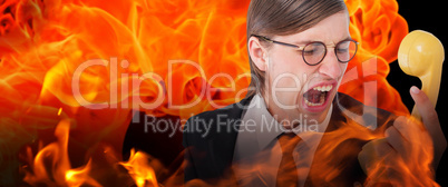 Composite image of geeky businessman shouting at retro phone