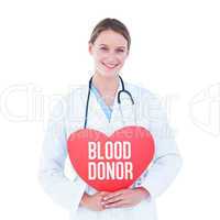Composite image of doctor holding red heart card