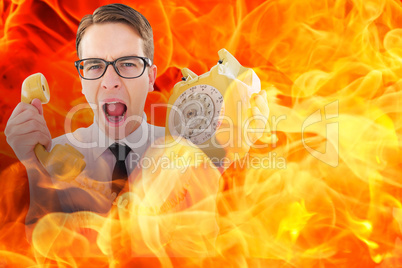 Composite image of geeky businessman shouting at retro phone