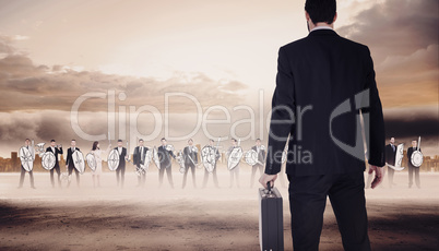 Composite image of rear view of businessman holding a briefcase