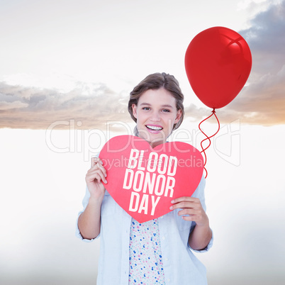 Composite image of woman holding heart card