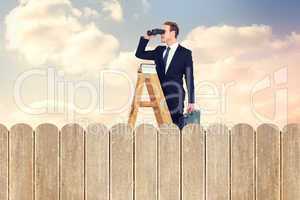 Composite image of businessman looking on a ladder