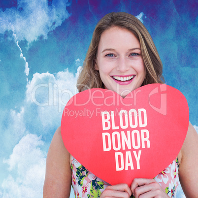 Composite image of woman holding heart card