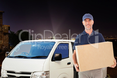 Composite image of happy delivery man holding cardboard box