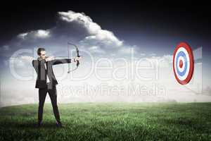 Composite image of businessman shooting a bow and arrow