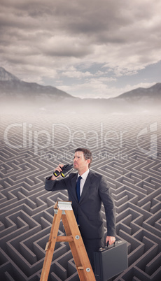 Composite image of businessman looking on a ladder