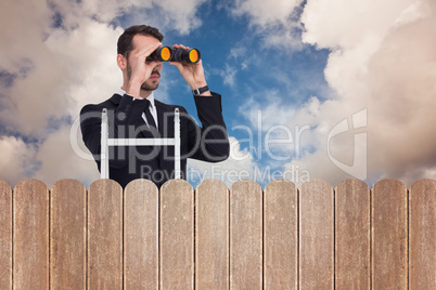 Composite image of businessman looking on a ladder