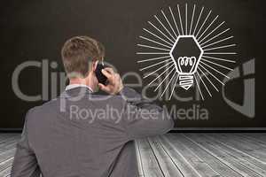 Composite image of back turned businessman on the phone