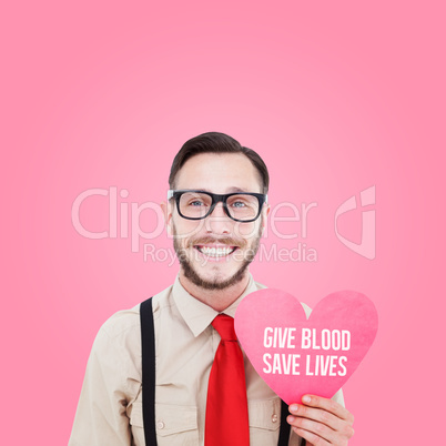 Composite image of geeky hipster smiling and holding heart card