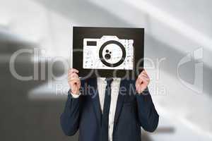 Composite image of businessman holding board