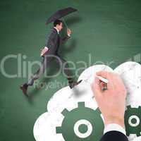 Composite image of businessman jumping holding an umbrella