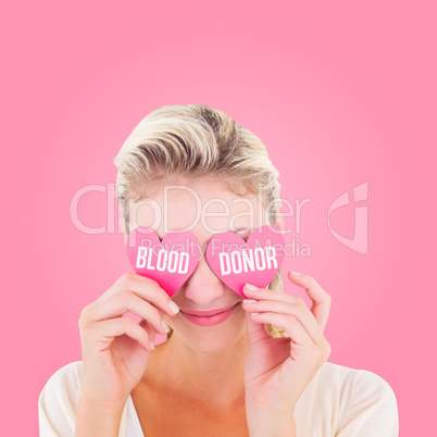 Composite image of attractive young blonde holding hearts over e