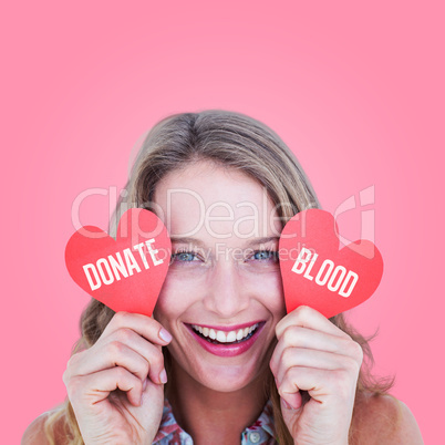 Composite image of woman holding heart cards