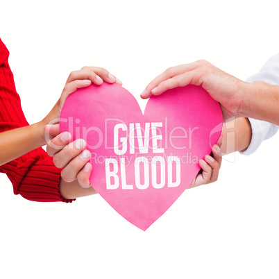 Composite image of couple holding a heart