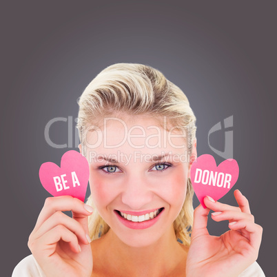 Composite image of attractive young blonde holding little hearts