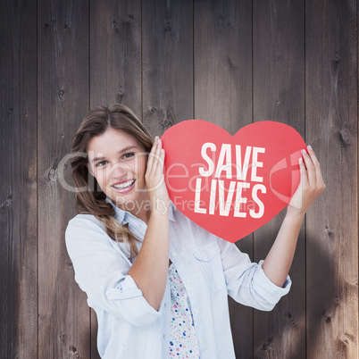 Composite image of woman holding heart card