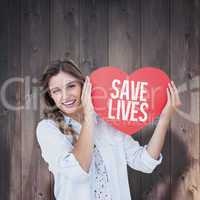 Composite image of woman holding heart card