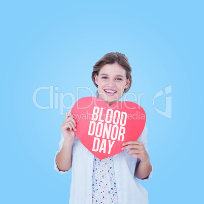 Composite image of woman holding heart card