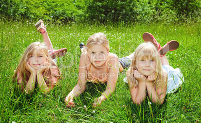 girls lying on green grass