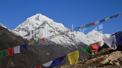 Colorful prayer flags and snow capped mountains