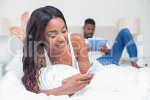 Relaxed couple using technology on bed